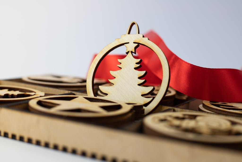Close-up of a wooden Christmas tree ornament with a red ribbon, perfect for festive decor.
